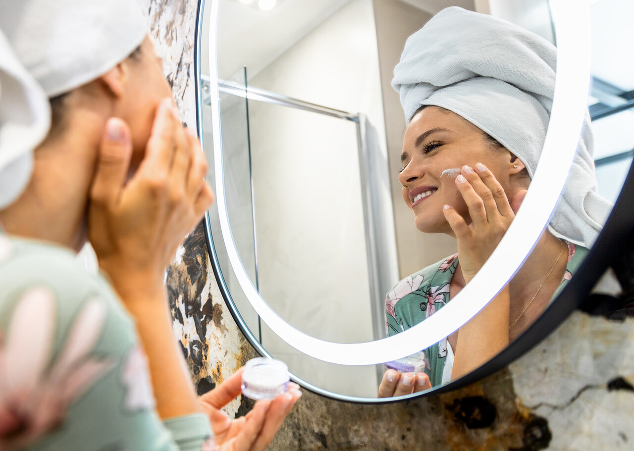 Home 13 smiling-woman-applies-facial-cream-in-her-bathroom-2025-01-29-12-30-37-utc_Easy-Resize.com
